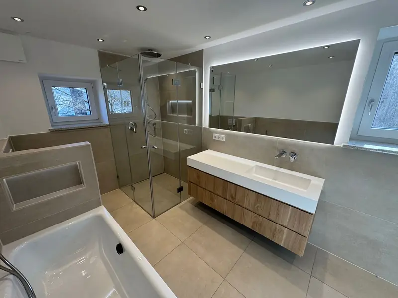 Badezimmer mit Glasdusche, Badewanne und Waschtisch mit Holzfront
