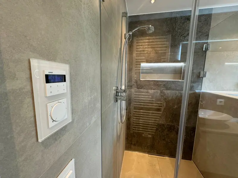 Dusche mit Wandfliesen, Duschnische und Glasabtrennung